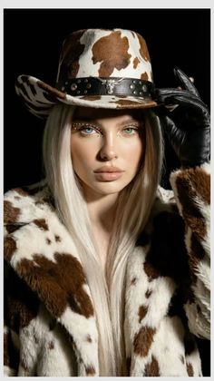 Woman with heterochromia and face gems wearing a cow print cowboy hat and faux fur coat
