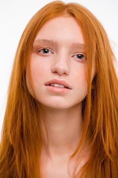 Close up portrait of a young woman with long red hair and freckles