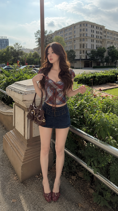 Woman in a plaid top and denim mini skirt outdoors in a city setting