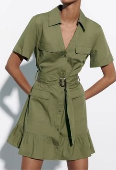 Woman wearing a green short-sleeve collared dress with a belted waist and ruffle hem