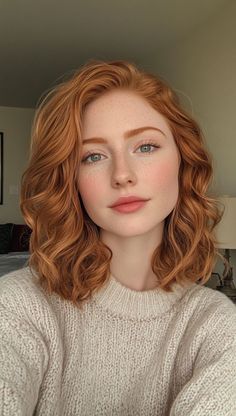 Woman with red wavy hair and freckles wearing a knitted sweater
