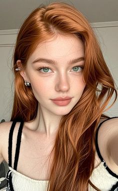 Woman with long red hair and green eyes wearing earrings