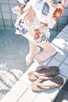 Person in a yukata with bare feet near water and geta sandals