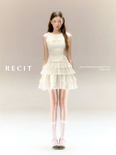 Woman in a white ruffle dress and white socks standing against a light background