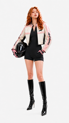Woman in a pink and white motorcycle jacket holding a helmet