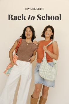 Two women posing with tote bags in a studio setting