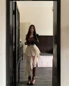 Woman with long hair wearing a leopard print top and asymmetrical skirt indoors