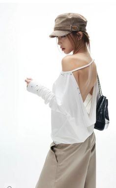 Woman in a corduroy hat and off-shoulder top with an exposed back