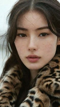 Woman with long hair and freckles wearing a leopard print coat
