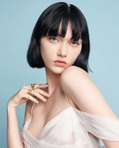Woman with pearl eye makeup and gold rings wearing a sheer white dress