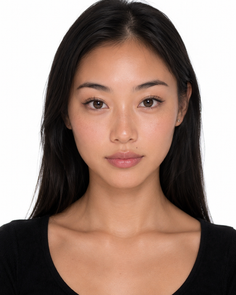 Woman with long black hair wearing a black top in a studio portrait