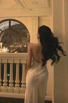 Woman in a backless dress with long dark hair in an elegant indoor setting