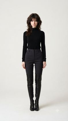 Woman with long dark hair wearing a black turtleneck and thigh-high boots