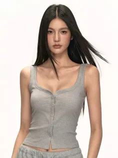 Woman with long black hair wearing a gray ribbed tank top in a studio