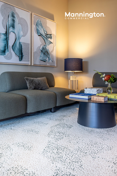 A modern living room with a green sofa, abstract art, and a coffee table