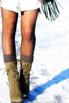 Person wearing polka dot tights and lace-up boots in the snow