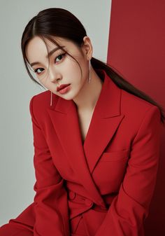 Woman in a red suit with a ponytail and long earrings in a studio