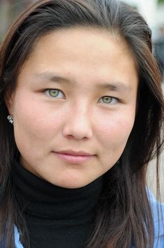 Woman with green eyes and long dark hair wearing a black turtleneck