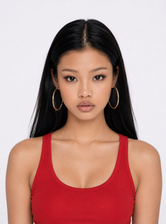 Woman with long black hair and gold hoop earrings wearing a red tank top