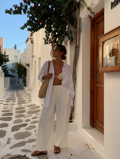 Woman in a white shirt and bikini top on a cobblestone street