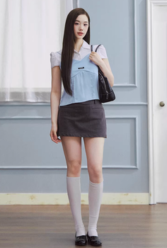 Woman with long dark hair wearing a mini skirt and knee-high socks indoors