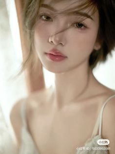 Woman with short hair and thin strap top in soft lighting
