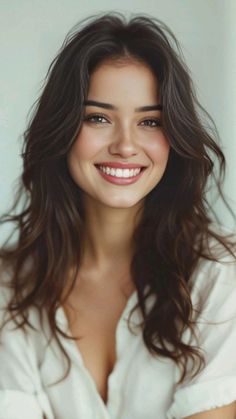Woman with long brown hair smiling in a white shirt