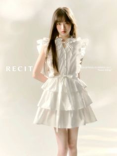 Woman in a white tiered dress with ruffle sleeves in a studio setting