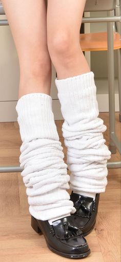 Person wearing white leg warmers and black loafers indoors
