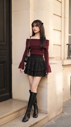 Woman in an off-shoulder top, ruffle skirt, and knee-high boots outdoors