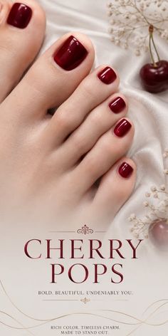 Close up of a foot with red nail polish on a satin fabric with cherries