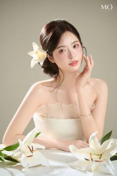 Woman with a white lily in her hair, wearing a strapless dress