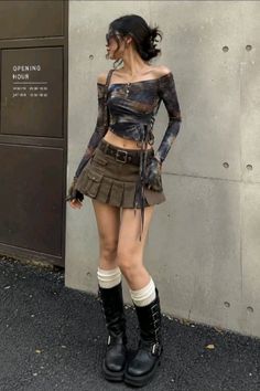 Woman in an off-shoulder top, mini skirt, and combat boots posing outdoors