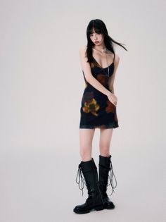 Woman with long black hair wearing a slip dress and knee-high boots