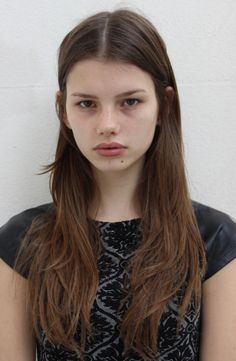 Woman with long brown hair and freckles wearing a black patterned top
