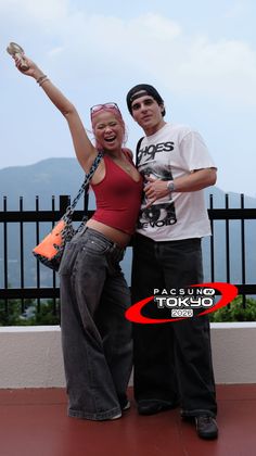 Two people posing outdoors with mountains in the background