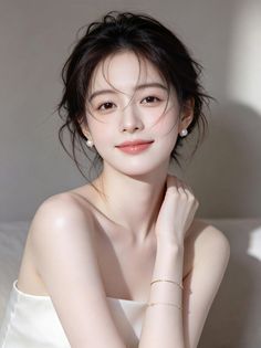 Woman with a messy bun and pearl earrings in soft lighting