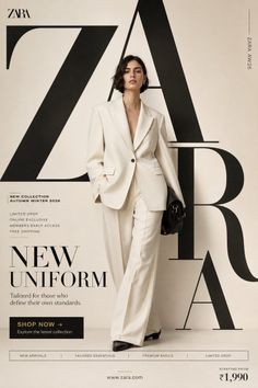 Woman in a cream suit holding a black handbag in a studio setting