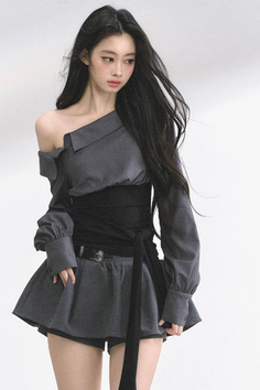 Woman with long black hair wearing an off-shoulder top and mini skirt