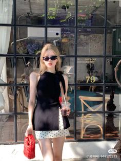 Woman with blonde hair and sunglasses in a black top and polka dot skirt