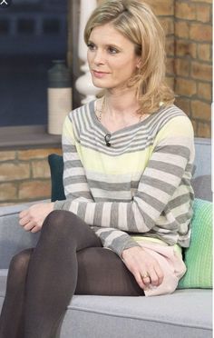 Woman with blonde hair wearing a striped long-sleeve shirt and tights, sitting indoors