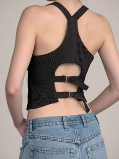 Person wearing a pinstripe cropped top with buckle straps and blue jeans