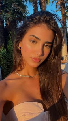 Woman with long brown hair in a strapless top during golden hour outdoors