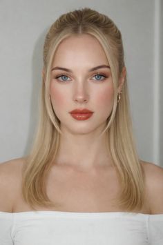 Woman with blonde hair and blue eyes wearing an off-shoulder top