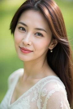 Woman with long brown hair wearing a white lace dress outdoors