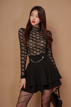 Woman in a sheer black top and short skirt with a chain belt