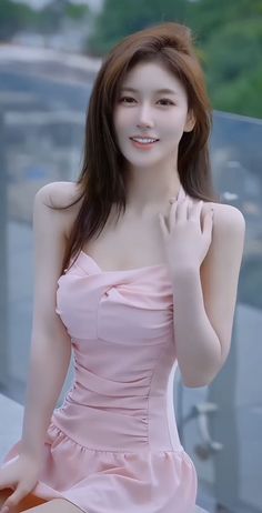 Woman in a pink dress with ruched fabric and exposed shoulders outdoors