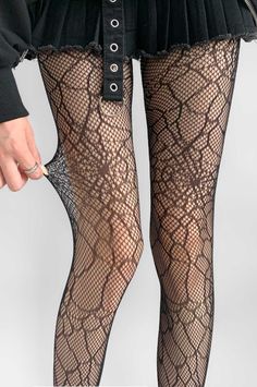 Person wearing fishnet stockings and a black skirt, pulling on the stocking