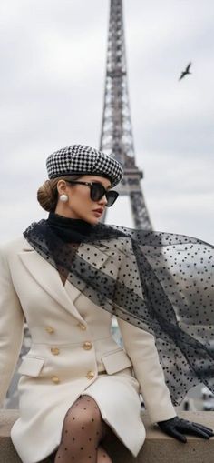 Woman in a beret and white blazer with the Eiffel Tower in the background