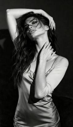 Woman in a satin dress with long hair posing in dramatic lighting